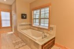 master bathroom on main with walk in shower and large tub